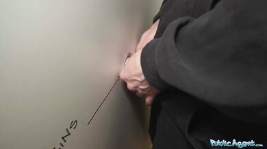 Nervózně vypadající žena kouří a šuká ptáka přes gloryhole