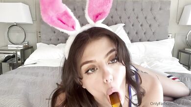 Zajíček Emily Black se hladí na posteli