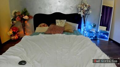 Prsatá webkamerová kočka provokuje na posteli v průsvitném bílém prádle