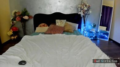 Prsatá webkamerová kočka provokuje na posteli v průsvitném bílém prádle
